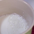 Skum mælk i hånden til en cappuccino