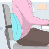 Sidder og arbejder med rygsmerter