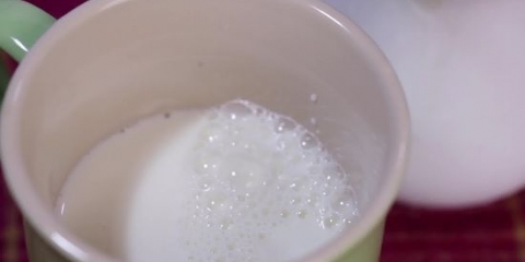 Skum mælk i hånden til en cappuccino